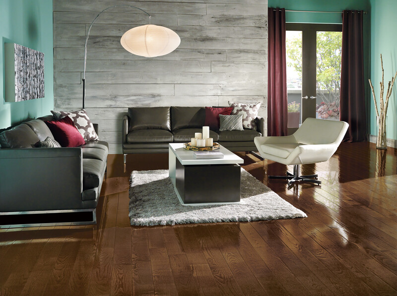 Seating area with a couch and chair showing red oak flooring